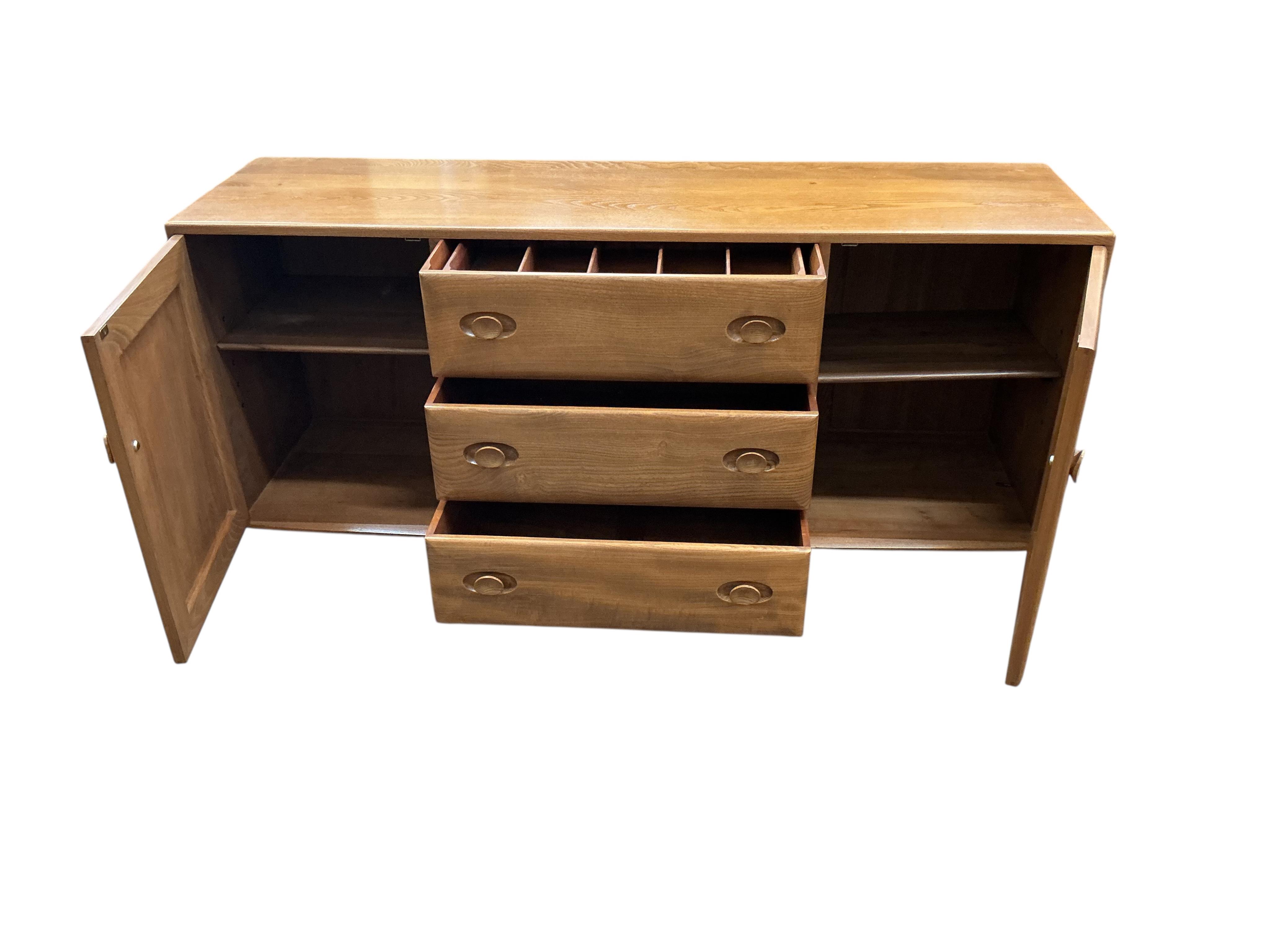 An Ercol Windsor elm sideboard, width 155cm, depth 43cm, height 69cm